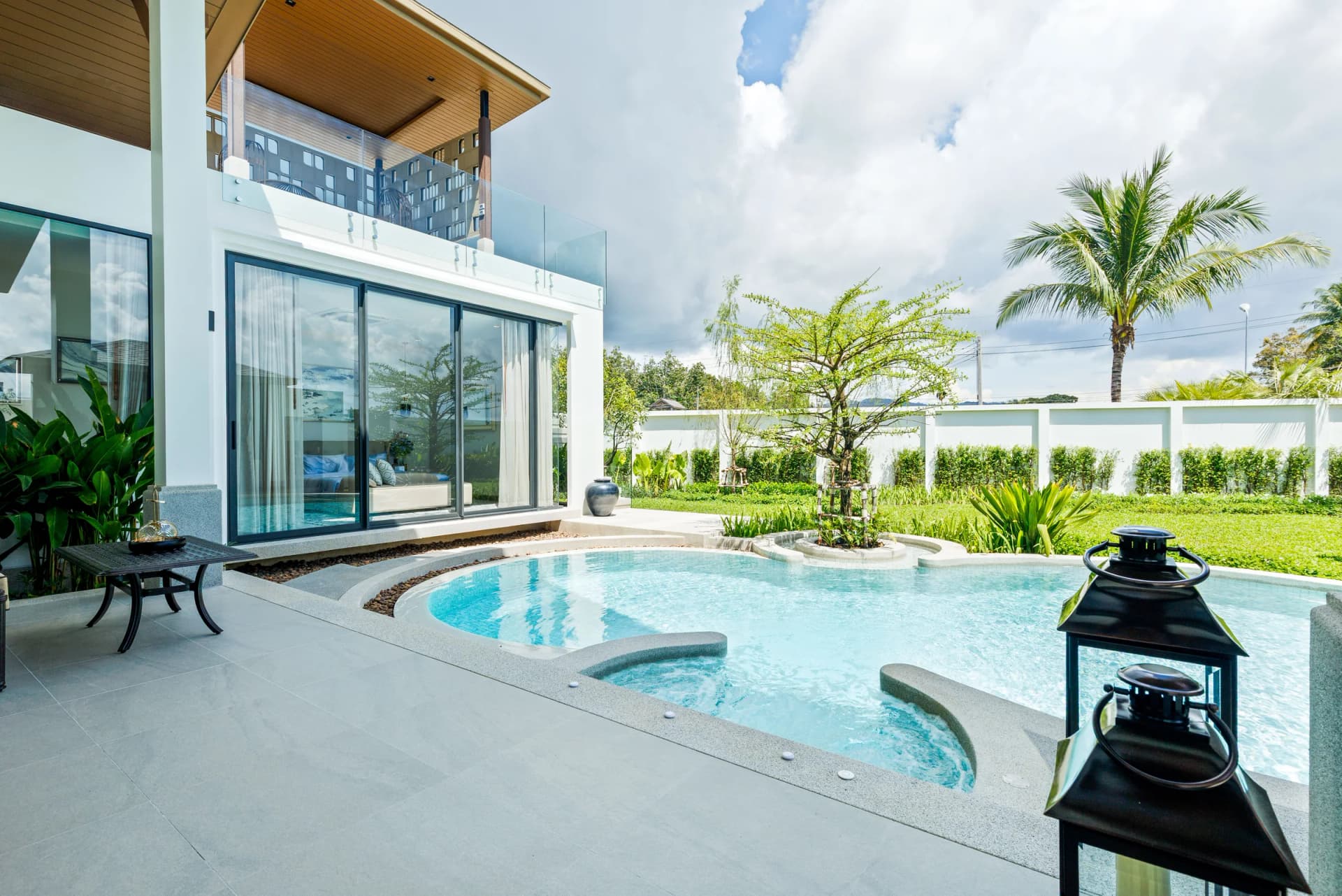 Low view across the pool and sun deck to the palms and the boundary hedge